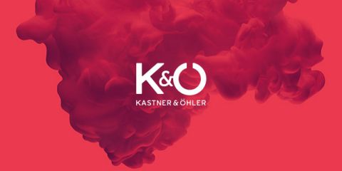 Ein roter, rauchiger Hintergrund mit dem weißen Logotext „K&O“ über „Kastner & Öhler“.