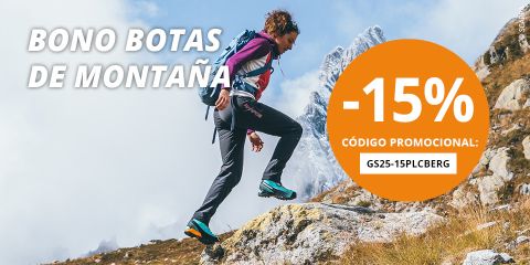 Una mujer camina por una ladera rocosa con picos nevados al fondo. Un gran círculo naranja muestra "-15%" y un código promocional para un descuento en botas de montaña con el texto "BONO BOTAS DE MONTAÑA".