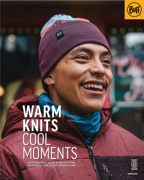 Una persona sonriente con gorro de punto marrón y chaqueta burdeos está de pie al aire libre. El texto en la imagen dice: "Prendas de punto cálidas, momentos geniales. Ropa sostenible para la cabeza y el cuello para cada aventura". Logotipo de Buff visible.