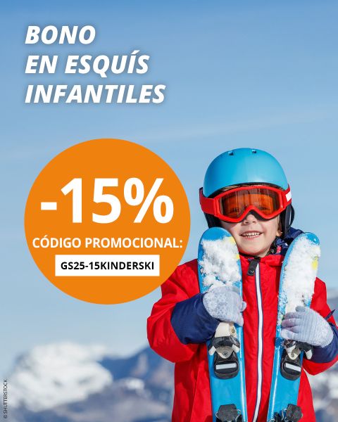 Un niño con ropa de esquí sonríe mientras sostiene los esquíes, con montañas nevadas al fondo. El texto promociona un descuento del 15% en pases de esquí para niños con el código GS25-15KINDERSKI.