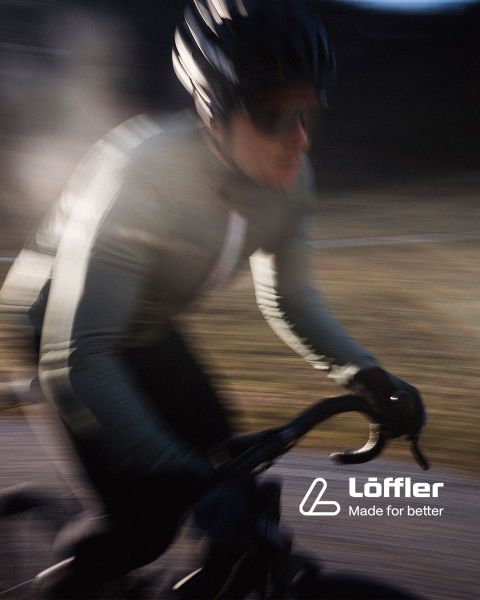 Dos ciclistas de montaña recorren un sendero rocoso en medio de una exuberante vegetación. Ambos llevan cascos y gafas de sol. En la esquina inferior derecha se puede leer el texto "Löffler Hecho para mejorar".