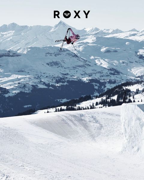 Tres mujeres nadan bajo el agua en trajes de baño en agua clara y azul. Una lleva una camisa de manga larga, las otras bikinis. La imagen está superpuesta con el logo blanco de "Roxy".