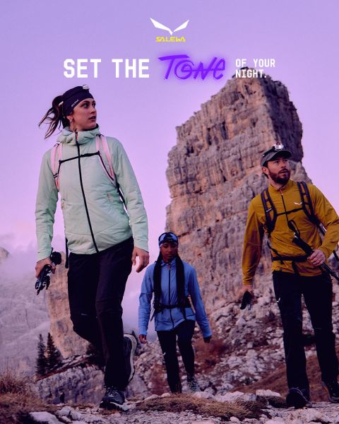 Una persona con chaqueta blanca y gafas de sol escala un terreno rocoso. El efecto de desenfoque de movimiento enfatiza la velocidad y el movimiento. Arriba está el texto "MXT Forward A Fast Story", a la derecha el logo de Salewa.