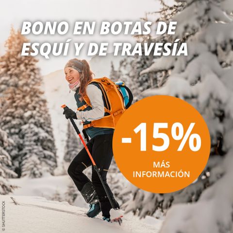 Una mujer sonriente con ropa de invierno camina con bastones de esquí entre árboles nevados. El texto ofrece un 15% de descuento en botas de esquí y de travesía, con "Más información" en un gran círculo naranja.
