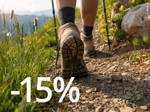 Fondo naranja con un gran texto blanco que dice: "-15% BONO BOTAS DE MONTAÑA*".