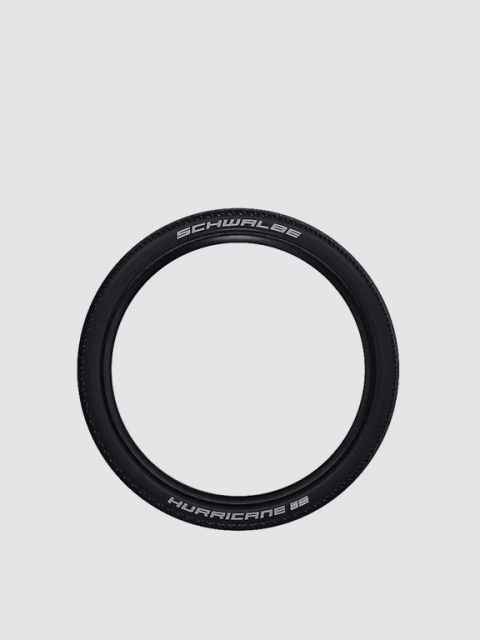 Un neumático de bicicleta Schwalbe Hurricane negro con letras blancas sobre un fondo gris claro y sencillo.