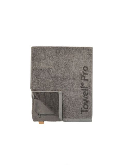 Toalla gris doblada con el texto "Towel Pro", un pequeño bolsillo con cremallera y un lazo marrón sobre un fondo blanco liso.