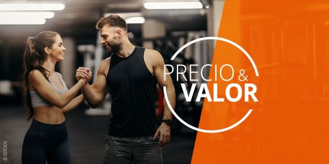 Un hombre sonriente y una mujer sonriente en ropa deportiva se dan la mano en el gimnasio, a la derecha se lee "Precio & Valor" sobre un fondo naranja.