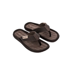 Un par de sandalias tipo chanclas de color marrón y negro con correas texturizadas sobre un fondo circular blanco.