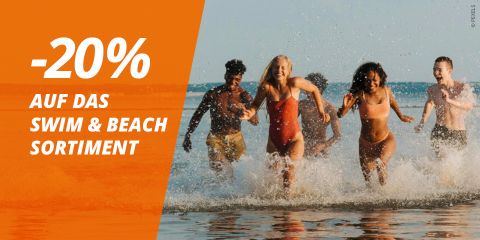 Cinco personas en trajes de baño caminan sonriendo por las aguas poco profundas del océano. El texto ofrece un 20% de descuento en la gama de productos de baño y playa en alemán sobre un fondo naranja.