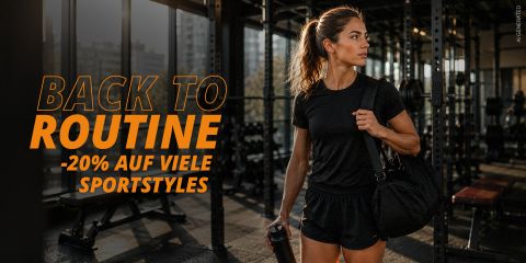 Una mujer con ropa deportiva negra sostiene en un gimnasio una bolsa de deporte y una botella de agua en la mano; el texto anuncia un 20 % de descuento en numerosos artículos deportivos.