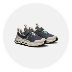 Un par de zapatillas deportivas negras y beige con detalles azules, cierres de velcro y suelas gruesas, representadas sobre un fondo blanco.